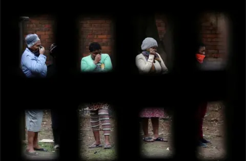 Reuters Women queue ahead of food distribution in Alexandra township on 28 April 28.