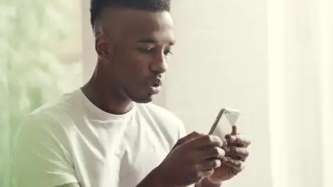 Getty Images Young man texting on a phone