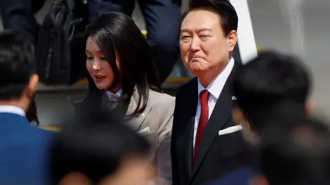 Reuters The president of South Korea and his wife greet people