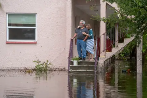 Greg Lovett / USA Today Network / Reuters Ken and Tina Kruse stand next to their apartment after the area flooded from Hurricane Idalia in Tarpon Springs, Florida, U.S. August 30, 2023. Greg Lovett/USA Today Network via REUTERS.