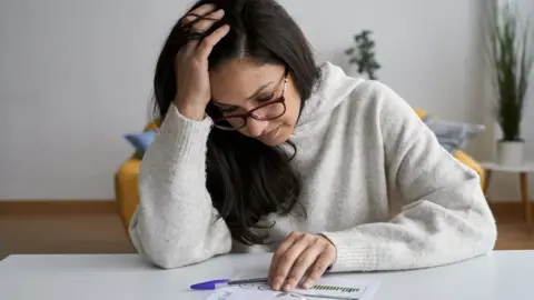 Getty Images Woman looking at energy bill