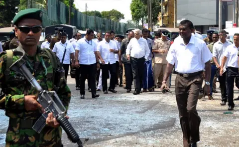 EPA Sri Lankan Prime Minister Ranil Wickremesinghe (C-R) arrives at the scene after an explosion at St Anthony's Church in Kochchikade in Colombo