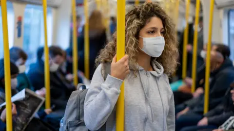 Getty Images Passengers on a train in face masks