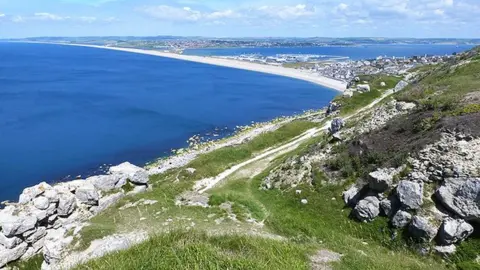 A view from Portland of Chesil Beach and Portland Harbour with Weymouth in the background