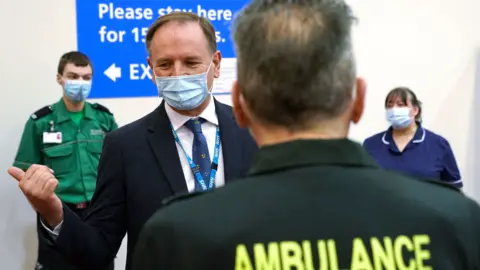 Sir Simon Stevens talks to a member of the vaccine team during a visit to the Centre for Life in Newcastle