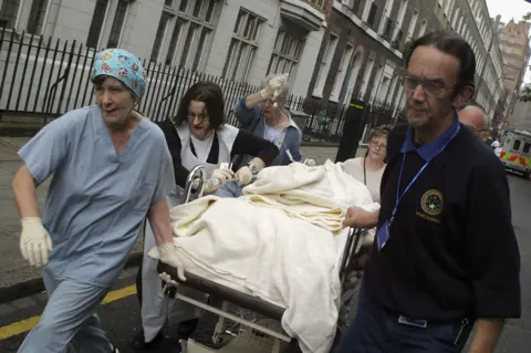 Getty Images Emergency workers take a body on a stretcher from Russell Square tube station