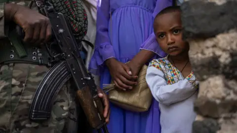 AFP A member of the Amhara police force stands guard next to Ethiopian Orthodox worshippers.