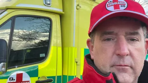 Ambulanceaid.co.uk Andy Morgan standing next to an ambulance donated to Ukraine