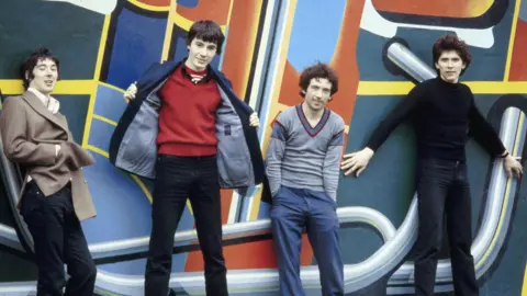 Fin Costello/Getty Images Steve Diggle, John Maher, Pete Shelley and Steve Garvey, pictured left to right in 1978