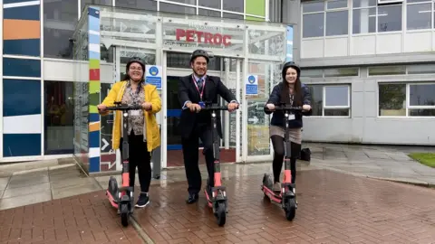 BBC Petroc CEO and students try out the scooters