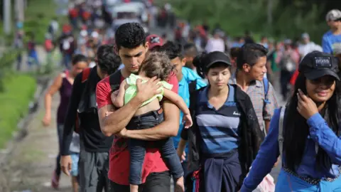 Getty Images Photograph showing caravan, including man clutching a small child