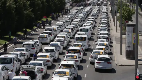 EPA Taxi drivers with their vehicles block the Paseo de la Castellana avenue in downtown during another day of taxi strikes, in Madrid, Spain, 30 July 2018