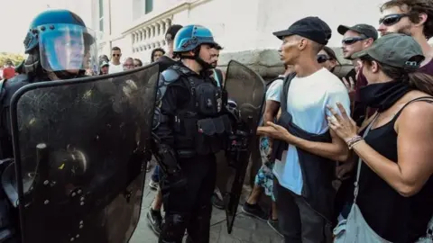 AFP Riot police speak to people during a gathering in Nantes over the death of Steve Maia Caniço