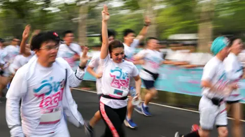 Reuters Runners flash the three-finger salute as they attend the "Run Against Dictatorship" event at a public park in Bangkok