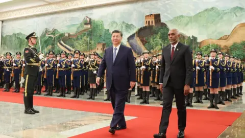 Getty Images The photo taken on January 10, 2024 shows Maldives' President Mohamed Muizzu (R) and Chinese President Xi Jinping walking during a welcome ceremony at the Great Hall of the People in Beijing.