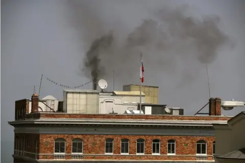 Getty Images Black smoke billows from a chimney on top of the Russian consulate on 1 September 2017 in San Francisco, California