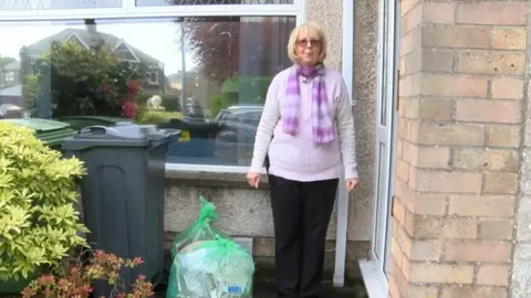 Pauline Bath outside her house