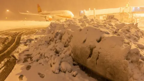 Getty Images A Chengdu Airlines Airbus A320 aircraft stands at Shenyang Taoxian International Airport during a heavy snowfall on November 8, 2021 in Shenyang, Liaoning Province of China