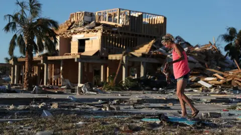 Joe Raedle/Reuters Roxy Atchley looks for items to salvage from where her friend's home once stood before it was knocked down when Hurricane Michael passed through the area on October 11, 2018 in Mexico Beach, Florida.
