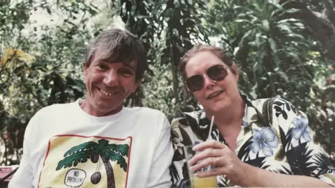 Family photo John and Helen Heath smiling, looking like they are on holiday