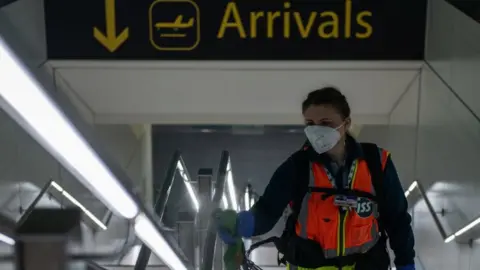 LONDON, ENGLAND - JUNE 09: Cleaners spray a peroxide based disinfectant on handrails and surfaces as a protective measure against the spread of Covid-19 inside the currently closed North Terminal at Gatwick Airport on June 9, 2020 in London, England.