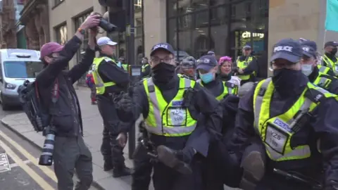 BBC Police carry away a protestor