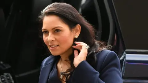 PA Media Home Secretary Priti Patel arrives at the National Police Chiefs" Council and Association of Police and Crime Commissioners joint summit, at the Queen Elizabeth II Conference Centre, in London