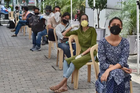 Getty Images Journalists waiting for tests in Mumbai