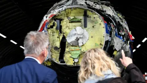 Reuters Two people inspect a reconstruction of the MH17 wreckage