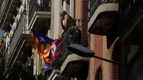 Reuters A Catalan separatist flag hangs from a balcony as a man smokes in Barcelona, Spain October 11, 2017