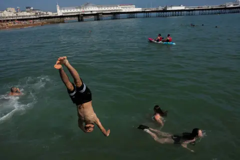Reuters A person diving into the sea by Brighton pier