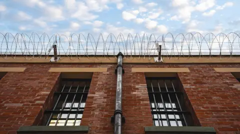 Stock image of a prison wall and wire