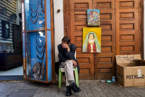 JEWEL SAMAD / AFP / GETTY IMAGES A shopkeeper waits for customers outside his store in a market area in Rabat.