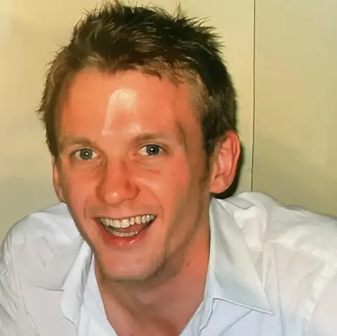 Joan Scourfield James is wearing a white shirt and smiling