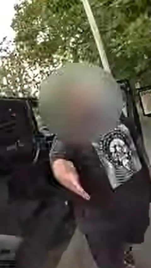 Man with blurred face and hand outstretched to shake hands outdoors in front of a car