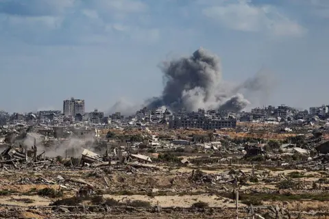 Anadolu via Getty Images Smoke rises amid ruins in Gaza