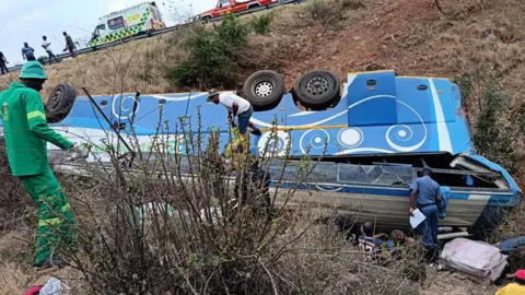 Supplied A blue and white bus, carrying Malawian and Zimbabwean nationals, on its roof just off the N1 highway