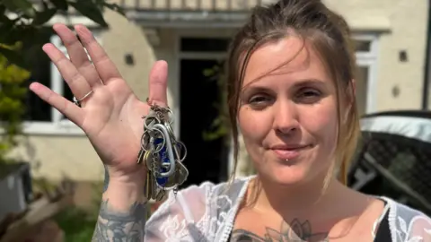 Lucie Lambourne holding keys outside her family home