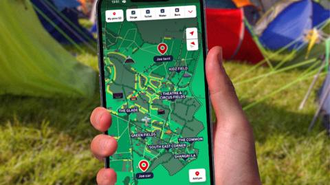 Hand holding smartphone at camp site
