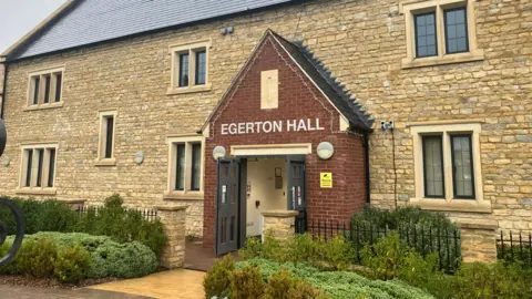 A building with beige-coloured brickwork and lettering above the door reading "Egerton Hall".