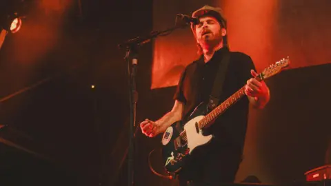 AJ Stark Gaz Coombes, lead singer of Supergrass, plays his electric guitar and sings as the band play at Bristol Sounds 2025