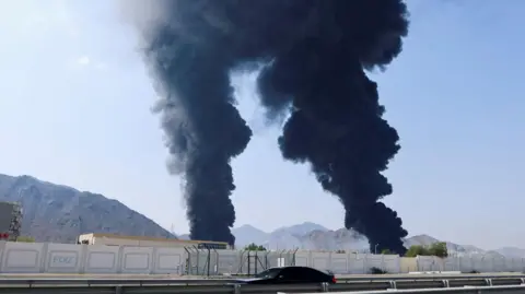 Smoke rises in the Fujairah oil industry zone, caused by debris after interception of a drone by air defenses