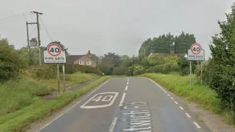 Google A country road with the words Pipe Gate on two signs which also show 40 mph speed limits. 