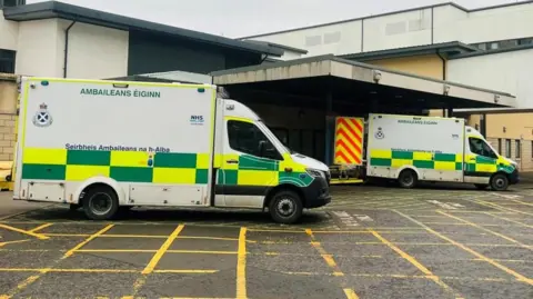 Two ambulances outside ARI with yellow lines across the tarmac