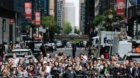 Reuters A crowd gathers against a barrier on a New York street
