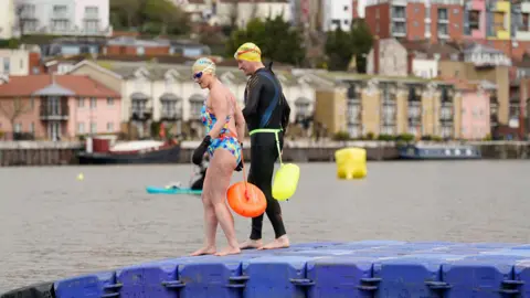 PA Swimmers David (right) and Karen Quartermain enter the water as they take part in the Bristol Harbour swim pilot trial on a temporary course in Baltic Wharf in Bristol