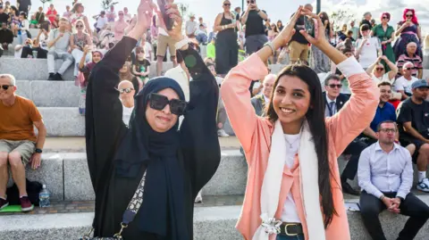 Stockton Council Two women raise their hands in the air and smile during the celebrations on Saturday. 