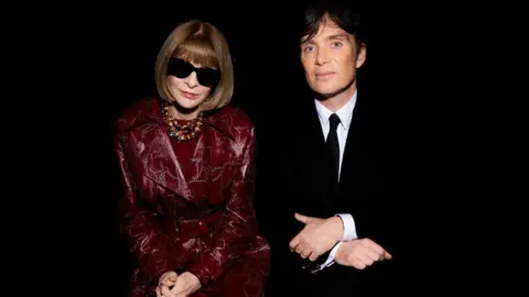 Getty Images Anna Wintour appears in black sunglasses and a red outfit, whilst Cillian Murphy wears a suit.