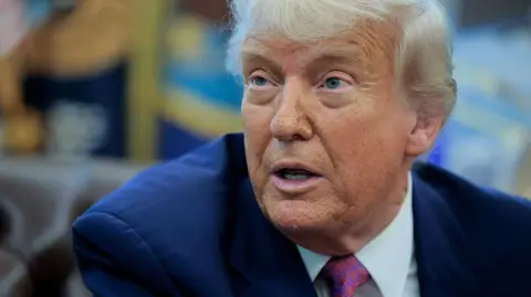 Donald Trump photographed speaking during a press briefing in the Oval Office
