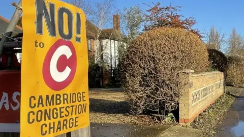 A 'No to Cambridge Congestion Charge sign' outside a driveway to a house.